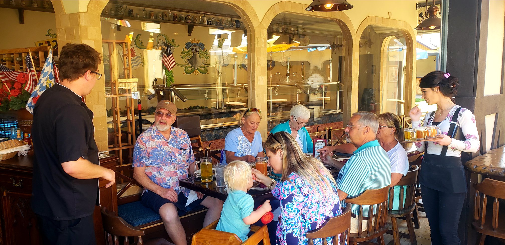 Group of people dining at the Cocoa Village Bier Gartien, The Chef and staff are attending to guests on a Village Food Tour